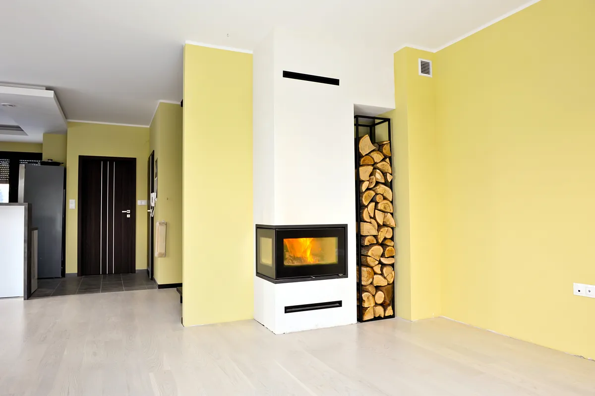 Habillage coupe-feu en plâtre pour insert à bois avec colonne de rangement à buches sur mesures